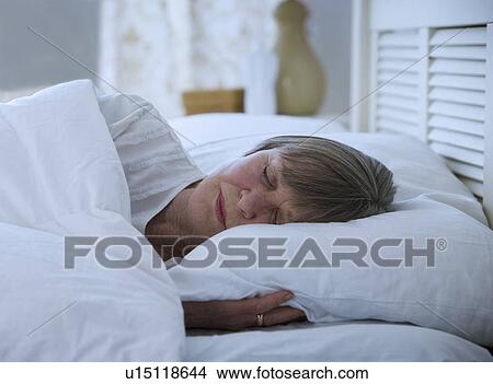 Picture - Senior woman sleeping in bed. Fotosearch