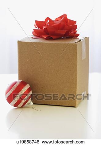 Shipping box with gift bow and Christmas ornament View Large Photo Image Stock Photograph - Shipping box with gift bow and Christmas ornament. Fotosearch