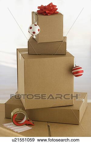 Stock Photo - Shipping boxes with gift bow and Christmas ornaments. Fotosearch