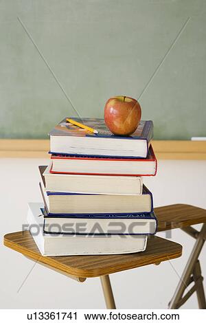 Stock Image - Stack of books and apple in classroom. Fotosearch