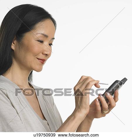 Studio shot of Asian woman using PDA View Large Photo Image Stock Photo - Studio shot of Asian woman using PDA. Fotosearch