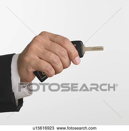 Studio shot of businessman holding car keys View Large Photo Image Stock Image - Studio shot of businessman holding car keys. Fotosearch