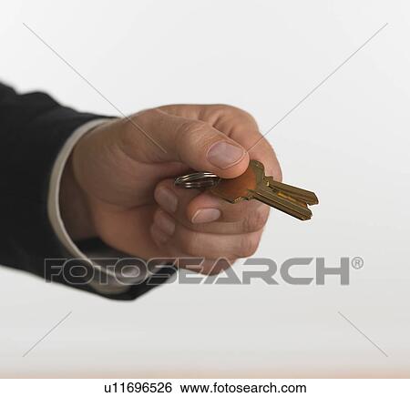 Studio shot of businessman holding keys View Large Photo Image Stock Photograph - Studio shot of businessman holding keys. Fotosearch