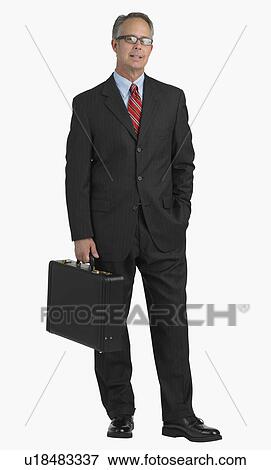 Stock Photo - Studio shot of businessman holding briefcase. Fotosearch
