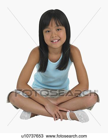 Stock Image - Studio shot of girl sitting cross-legged. Fotosearch