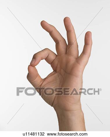 Stock Image - Studio shot of hand giving the okay sign. Fotosearch