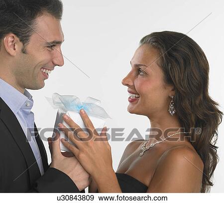 Stock Photo - Studio shot of man giving woman gift. Fotosearch