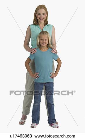 Stock Image - Studio shot of mother resting hands on daughter's shoulders. Fotosearch