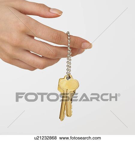 Stock Photo - Studio shot of woman's hand holding keys. Fotosearch