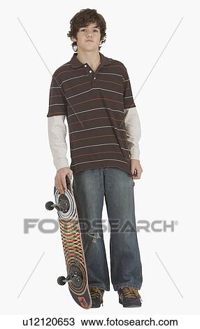 Teenaged boy holding skateboard View Large Photo Image Stock Image - Teenaged boy holding skateboard. Fotosearch