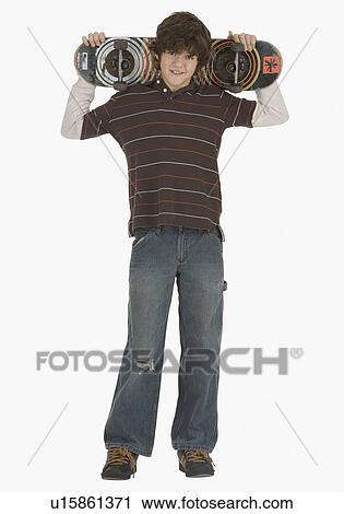 Teenaged boy holding skateboard View Large Photo Image Stock Image - Teenaged boy holding skateboard. Fotosearch