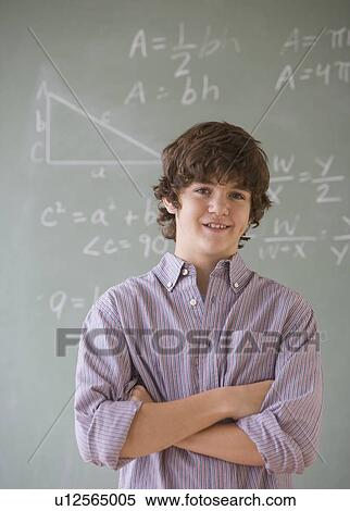 Stock Photography - Teenaged boy in front of blackboard with math equations. Fotosearch