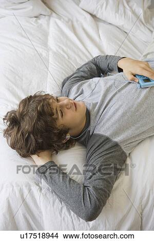 Teenaged boy listening to mp3 player View Large Photo Image Picture - Teenaged boy listening to mp3 player. Fotosearch