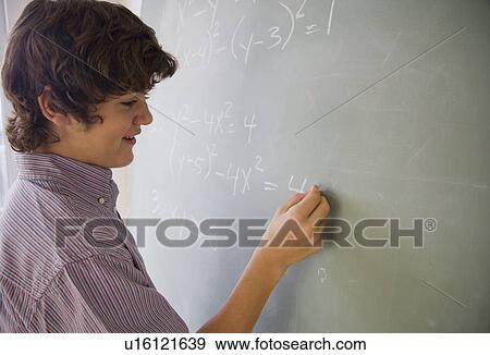 Teenaged boy writing math equations on blackboard View Large Photo Image Stock Photo - Teenaged boy writing math equations on blackboard. Fotosearch