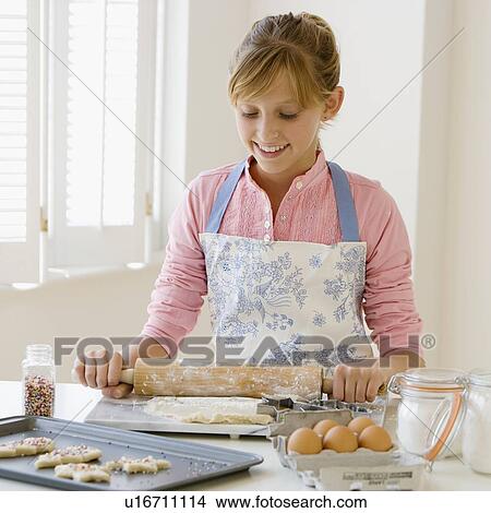 Picture - Teenaged girl baking cookies. Fotosearch