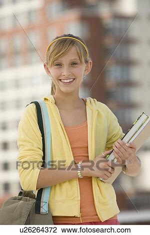 Teenaged girl holding school books View Large Photo Image Stock Image - Teenaged girl holding school books. Fotosearch