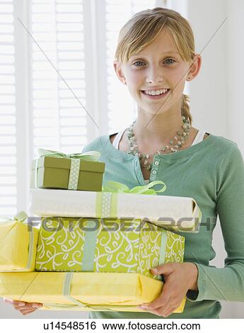 Teenaged girl holding stack of gifts View Large Photo Image Stock Photograph - Teenaged girl holding stack of gifts. Fotosearch