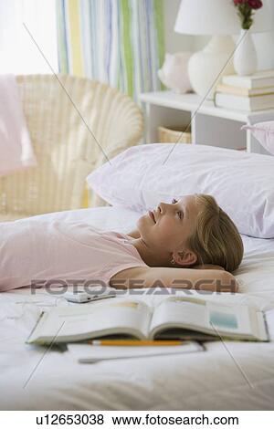 Stock Photo - Teenaged girl laying on bed. Fotosearch