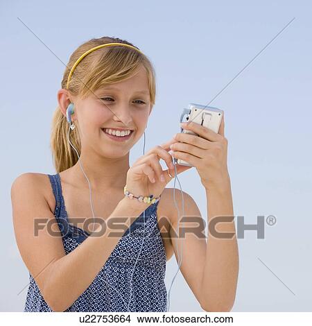 Teenaged girl listening to mp3 player View Large Photo Image Picture - Teenaged girl listening to mp3 player. Fotosearch