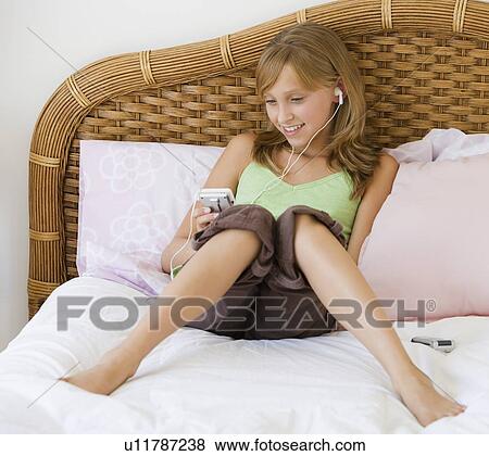 Teenaged girl listening to mp3 player View Large Photo Image Stock Photo - Teenaged girl listening to mp3 player. Fotosearch