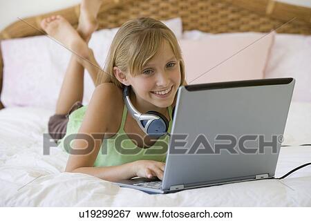 Stock Photo - Teenaged girl typing on laptop. Fotosearch