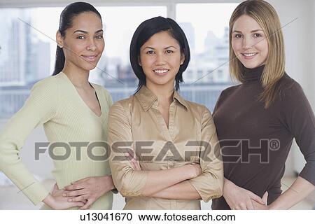 Stock Image - Three women smiling indoors. Fotosearch
