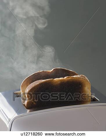 Stock Image - Toast burning in toaster. Fotosearch