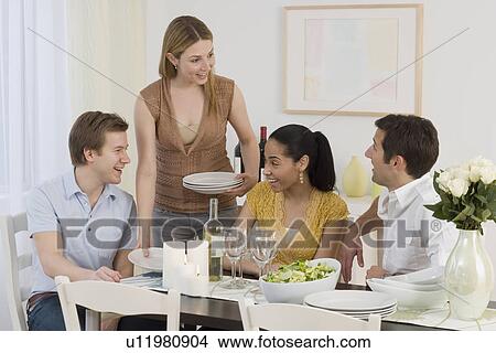 Picture - Two couples having dinner party. Fotosearch