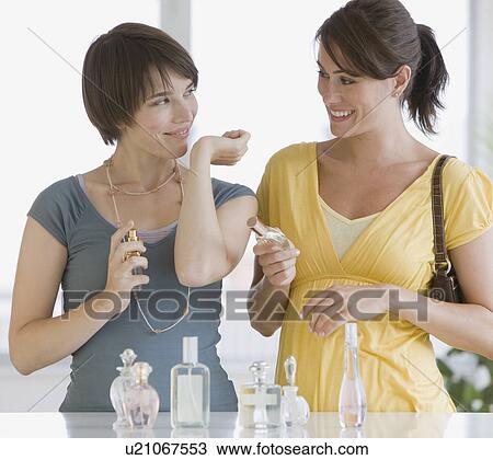Stock Image - Two women trying perfumes. Fotosearch