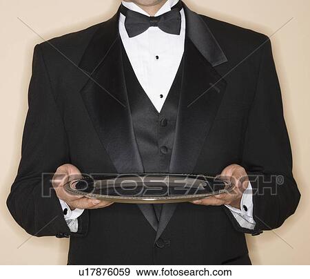 Stock Photo - Waiter in tuxedo holding silver platter. Fotosearch