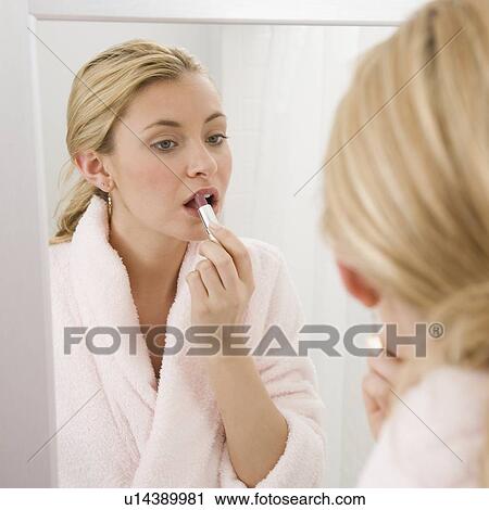 Woman applying lipstick in mirror View Large Photo Image Stock Image - Woman applying lipstick in mirror. Fotosearch