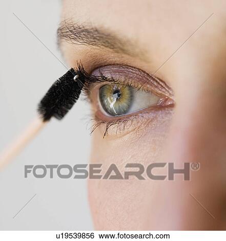 Stock Photograph - Woman applying mascara. Fotosearch