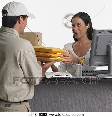 Woman behind counter receiving delivery View Large Photo Image Stock Photo - Woman behind counter receiving delivery. Fotosearch