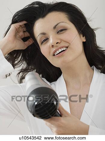 Woman blow drying hair View Large Photo Image Stock Image - Woman blow drying hair. Fotosearch