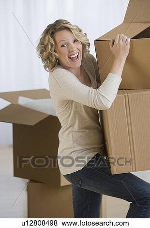 Stock Photo - Woman carrying moving boxes. Fotosearch