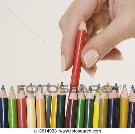 Stock Image - Woman choosing colored pencil. Fotosearch