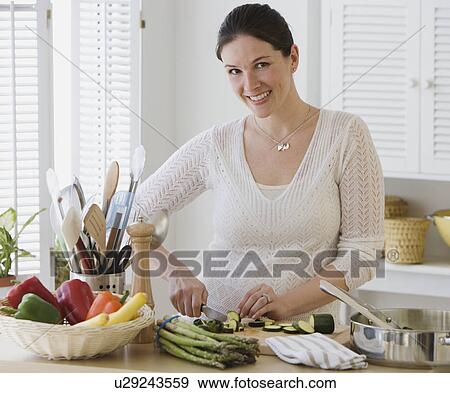 Stock Photo - Woman chopping vegetables in kitchen. Fotosearch