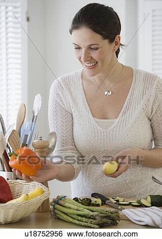 Woman chopping vegetables in kitchen View Large Photo Image Stock Photograph - Woman chopping vegetables in kitchen. Fotosearch