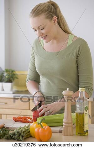 Woman chopping vegetables in kitchen View Large Photo Image Stock Photograph - Woman chopping vegetables in kitchen. Fotosearch