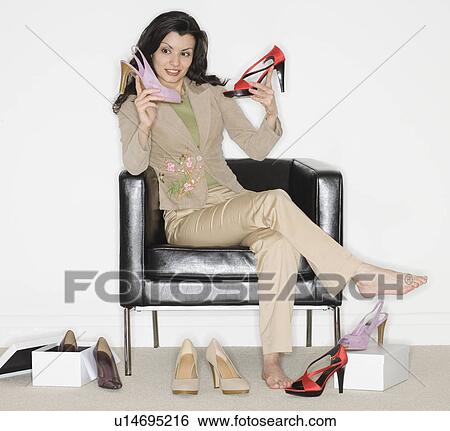 Woman comparing shoes at shop View Large Photo Image Stock Photograph - Woman comparing shoes at shop. Fotosearch