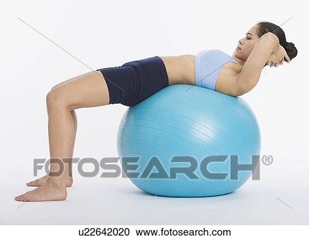 Woman doing crunches on exercise ball View Large Photo Image Stock Image - Woman doing crunches on exercise ball. Fotosearch