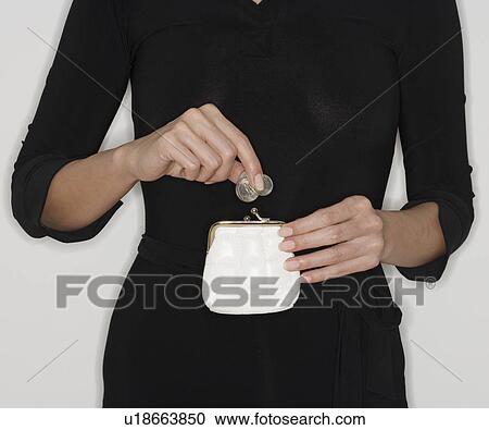 Woman dropping coins in purse View Large Photo Image Stock Image - Woman dropping coins in purse. Fotosearch