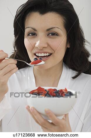 Woman eating bowl of fruit View Large Photo Image Stock Photo - Woman eating bowl of fruit. Fotosearch