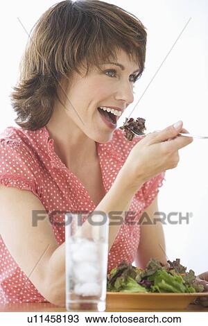 Stock Image - Woman eating salad. Fotosearch