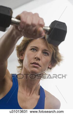Stock Image - Woman exercising with weight. Fotosearch