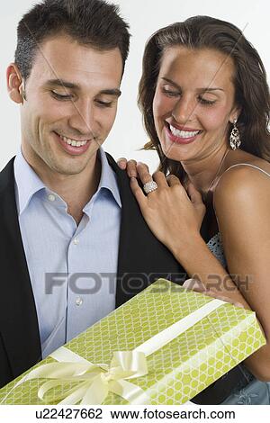 Stock Image - Woman giving man gift. Fotosearch