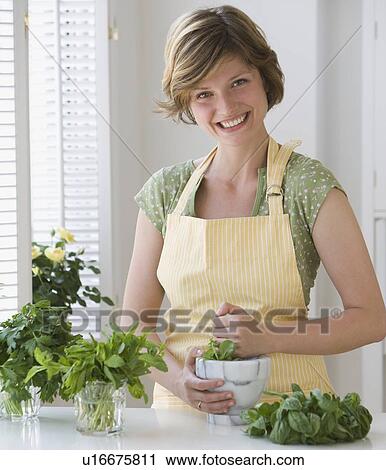 Woman grinding fresh herbs View Large Photo Image Stock Image - Woman grinding fresh herbs. Fotosearch