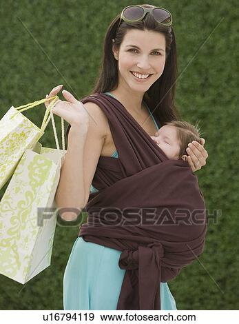 Woman holding baby in sling View Large Photo Image Stock Photo - Woman holding baby in sling. Fotosearch