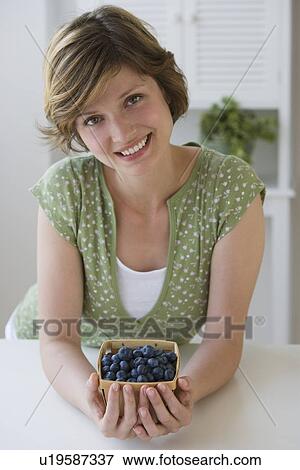 Stock Photo - Woman holding box of blueberries. Fotosearch