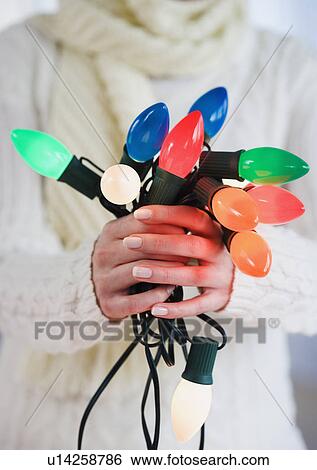 Woman holding bunch of Christmas lights View Large Photo Image Stock Photograph - Woman holding bunch of Christmas lights. Fotosearch